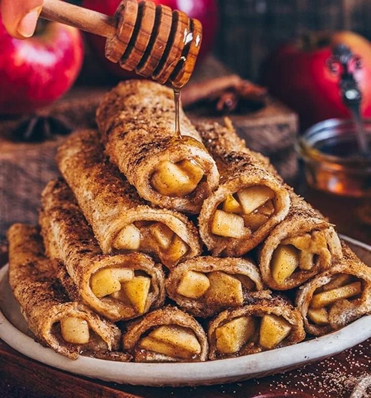 Leckeres Apfel-French-Toast auf einem Teller mit frischen Äpfeln und Zimt