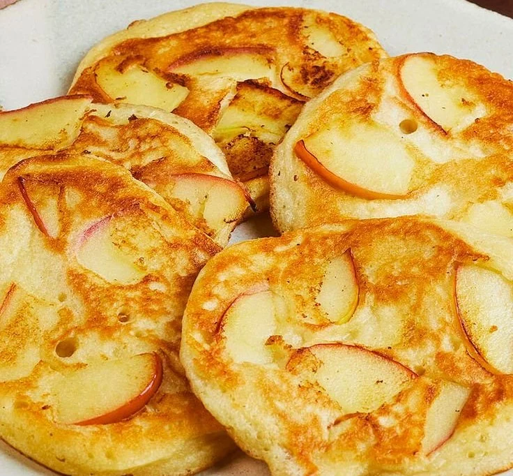 Leckere Apfelpfannkuchen mit Äpfeln und Zimt auf einem Teller