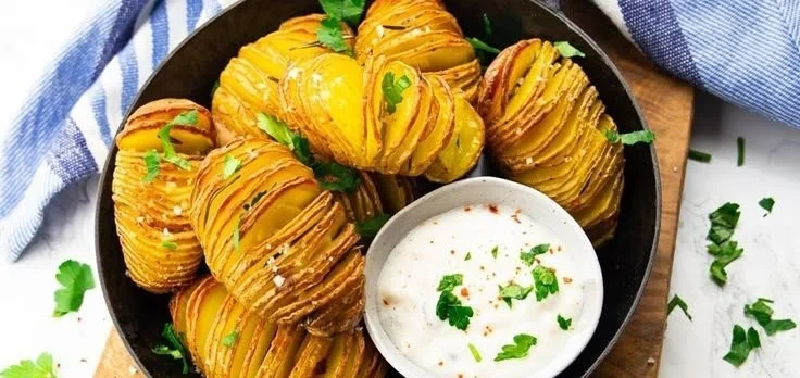Fächerkartoffeln frisch aus dem Ofen mit Kräutern und Gewürzen garniert.