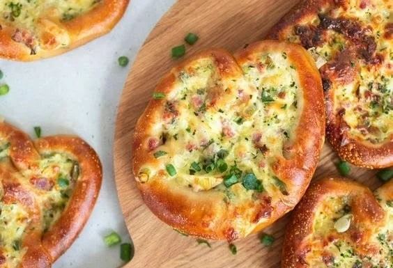 Flammkuchen-Brezeln als köstlicher Partysnack auf einem Teller serviert.