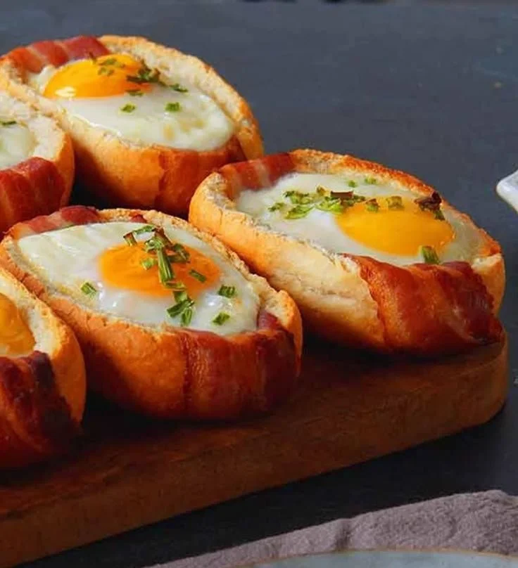 Gefüllte Frühstücksbrötchen mit Ei, Bacon und Käse auf einem Tisch