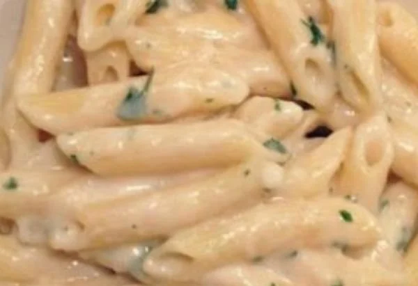 Nudeln mit cremiger Knoblauch-Käsesosse auf einem Teller serviert