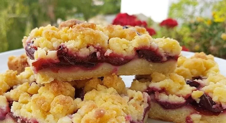 Köstlicher Pflaumenkuchen auf einem Teller, serviert mit frischer Sahne.