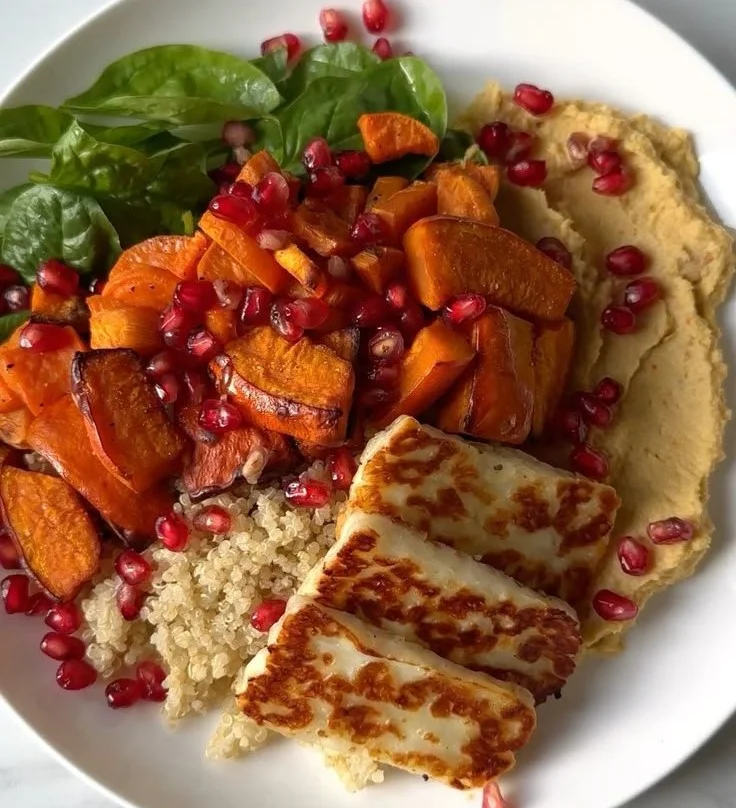 Gesundes Gericht Quinoa mit Hokkaido-Kürbis und Süßkartoffel serviert in einer Schüssel