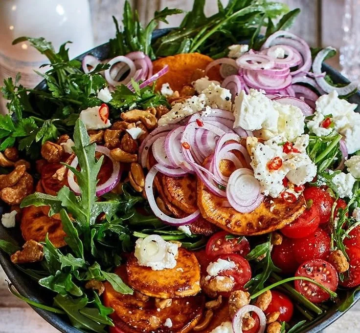 Warmer Süßkartoffelsalat mit frischen Zutaten auf einem Teller
