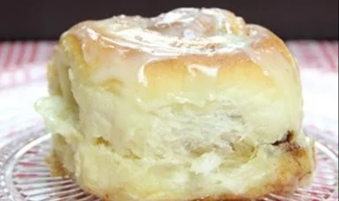 Zimtschnecken mit süßem Frischkäse-Topping auf einem Teller